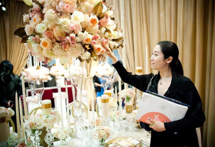 Image of professional planner inspecting the details of a flower arrangement.